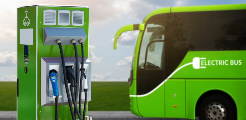 Electric bus with charging point in foreground