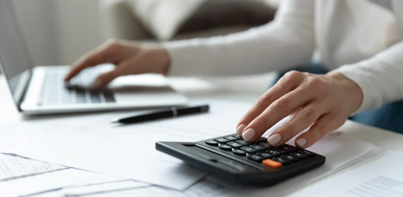 Woman using calculator and laptop