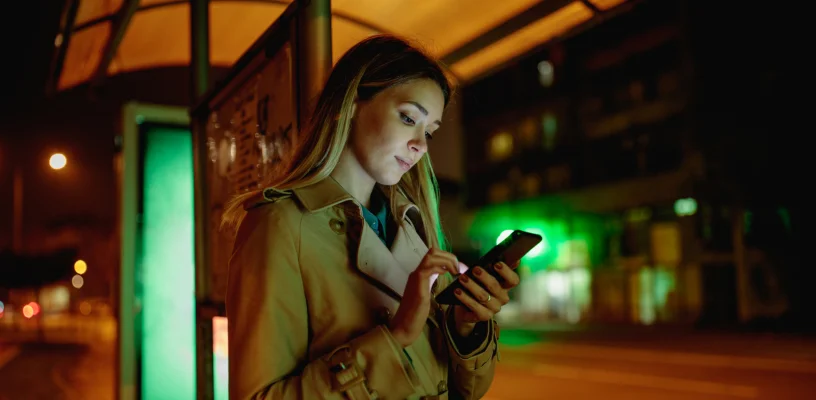 Woman standing at bus stop at night